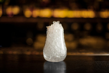 Decorative cocktail glass of crushed ice standing on the bar stand