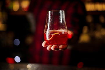 Bartender serving glass of a Sazerac cocktail