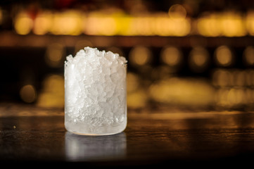 Cylindrical cocktail glass of crushed ice standing on the bar counter