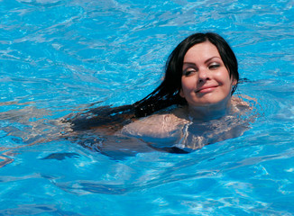 young woman smiling in a swimming pool 