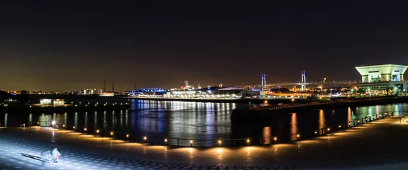 Foto op Plexiglas A panoramic nightscape of Yokoham bay with the Yokohama Bay Bridge in the distance © Peter Austin