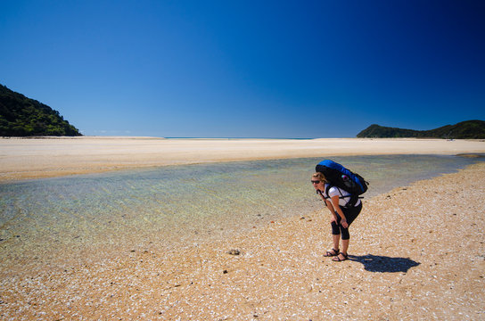 Woman hiker tired when crossing Awaroa inlet, New Zealand