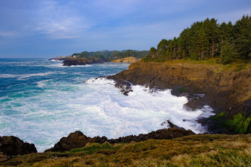 Ocean waves crashing onto the rocks in the sunset
