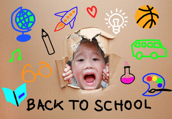Adorable little Asian kid girl looking through hole on cardboard with Back to school and education concept.