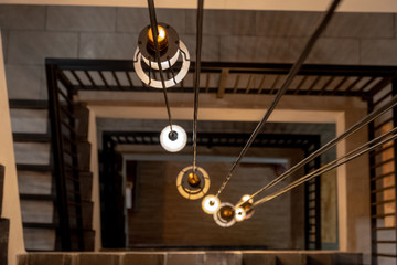 Staircase with Spiral Staircase build step by cement and vintage chandelier light on top floor.