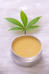Cannabis hemp cream with marijuana leaf over white background