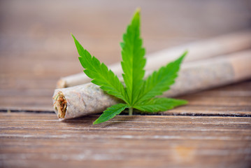Hand rolled marijuana joints with cannabis leaf
