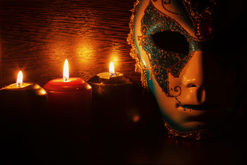 masquerade mask and candles on a black background