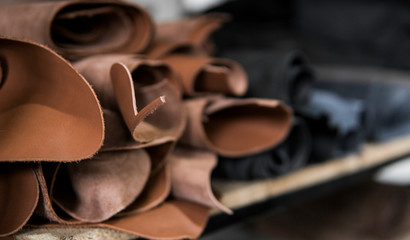 Different pieces of leather in a rolls. The pieces of the colored leathers. Rolls of natural brown...