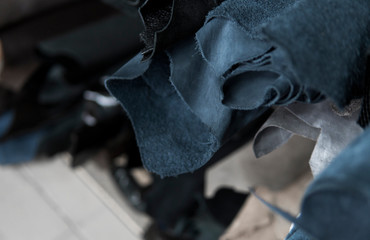 Different pieces of leather in a rolls. The pieces of the colored leathers. Rolls of blue and black...