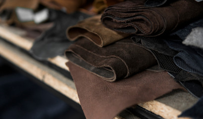 Different pieces of leather in a rolls. The pieces of the colored leathers. Rolls of natural brown...