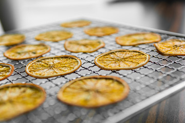 Candied orange slices on grid for drying. Dried fruits which can be used as a decoration to the meal or cocktails. Healthy vegetarian food rich on a vitamins and microelements.