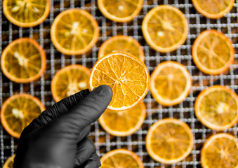 Candied orange slices on grid for drying. Dried fruits which can be used as a decoration to the meal or cocktails. Healthy vegetarian food rich on a vitamins and microelements.