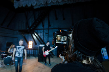 Professional videographer using cinema digital video camera for filming a music video.