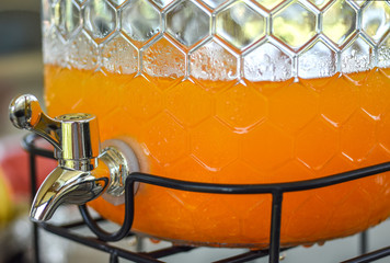 Glass cooler for fresh orange juice at catering station ready for breakfast service.