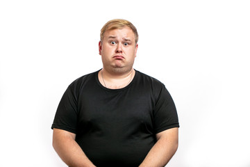 Stressed overweight plump male having sad expression wearing black T-shirt curving his lip knowing...