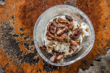 Close up fried pepper pork with white rice in the silver plate.