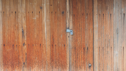 Wooden retro, vintage folding door orange color tone background has key lock in Thailand country