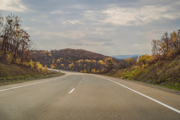 Amazing view with colorful autumn forest with asphalt mountain road. Beautiful landscape with empty...