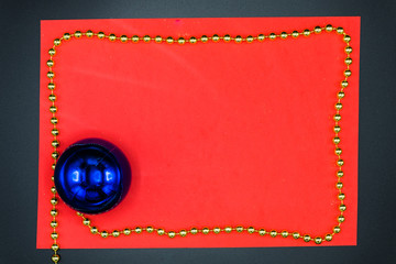 Red copy space with golden border chord and christmas blue ball.