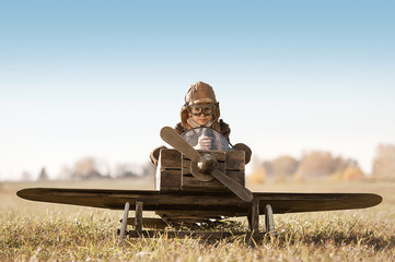 Portrait of the young aviator in a toy airplane child