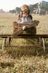 Portrait of the young aviator in a toy airplane child