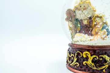 Christian nativity scene snow globe close-up. Left copy space.