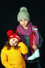 Portrait of children in warm sweaters on a dark background . The concept of winter clothing for sports and leisure