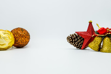 Cone pine, golden bells decorations, red star and christmas tree ball on white background.