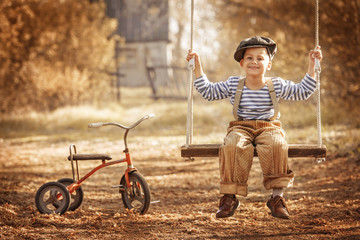 Small boy with toys on a swing