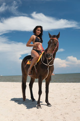 Sexy girl riding horse at beach. Fair tan skin and smooth.