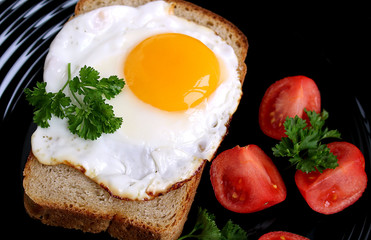 scrambled eggs on a plate with black bread