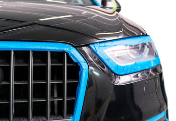 Car in applying blue protective tape before polishing. Buffing and polishing car. Car detailing. Car service