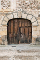 Fototapeta na wymiar Wooden door in a stone wall
