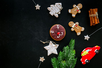 Festive New Year candies. Traditional gingerbread cookies in different shape for decoration new year tree on black background top view copy space