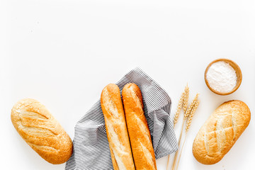 White bread. Fresh rustic homemade bread and loaf on tablecloth decorated with ears and flour on...