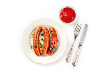 An overhead photo of a plate of fried sausages with ketchup, shot from above on a white background with copy space