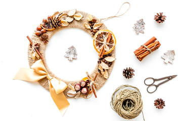 Christmas decoration concept. Creative christmas wreath made of thread near matherials and instruments, sciccors on white background top view