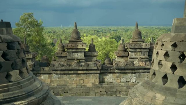 View from the top of Borobudur temple in java, Indonesia, stone stupas and ornaments in front on sunny evening