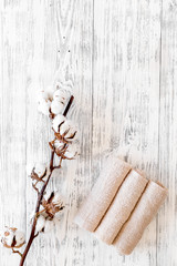 Cotton towels high quality. Set of towels twisted coil near dry cotton flowers on white wooden background top view copy space