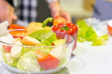 cooking salad with vegetables and greens on table