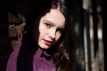 Fototapeta premium girl in plaid shirt posing against the wall