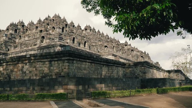 Borobudur temple and green tree low angle shot in Java, Indonesia in the evening