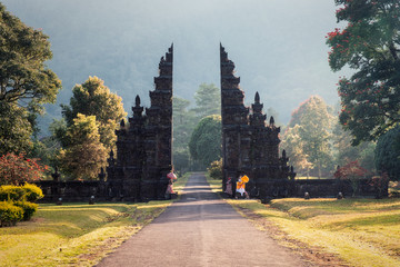 Ancient bali gate with pathway in garden