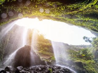 Majestic Madakaripura waterfall flowing on rocky cliff