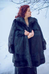 Elegant plus size woman in fur coat at winter. Big Lady at park, cold time. Fashionable womens...