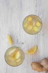 Homemade ginger tea with lemon on white wooden background, overhead view. Flat lay, from above, top view. Closeup.