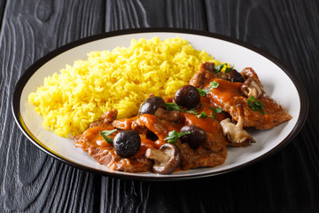 Fricando is a Catalan slow cook beef stew, simmered in wine and mushrooms sauce served with yellow rice close-up. Horizontal