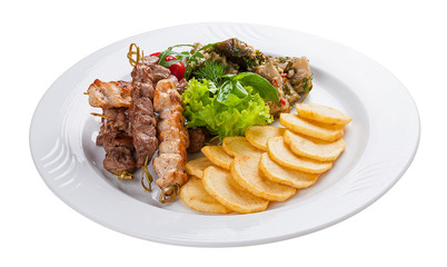 Set of kebabs with vegetable garnish on a white plate