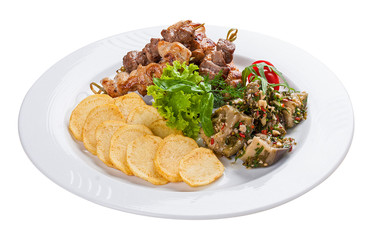 Set of kebabs with vegetable garnish on a white plate